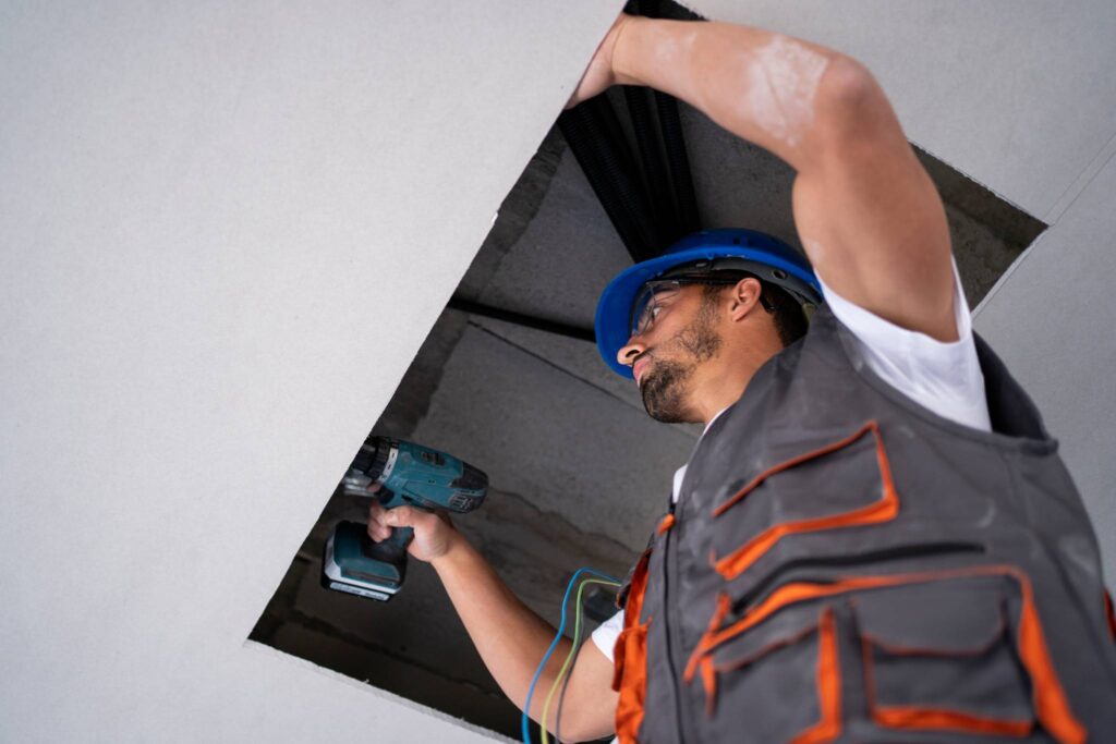 Hombre revisando cielo raso construido con drywall